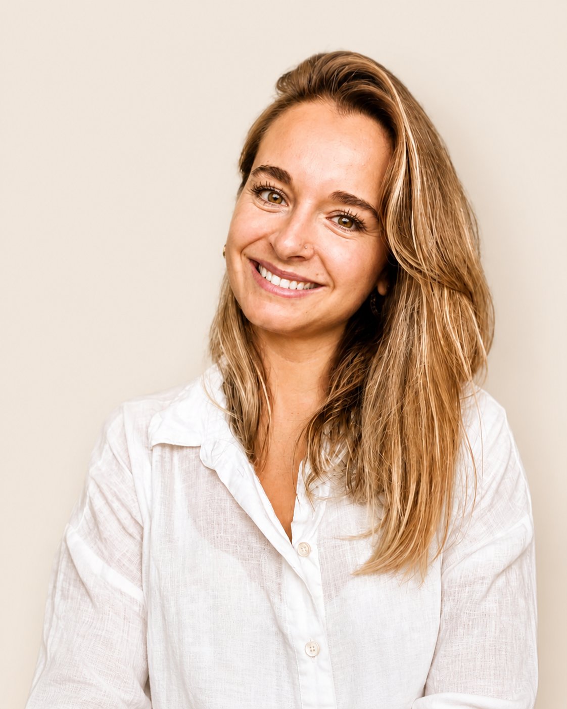 Retrato de Daniela Barraza, sonriente, fondo crema.